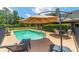Inviting backyard pool with patio furniture and lush landscaping offers a perfect outdoor retreat at 2151 Se 59Th St, Ocala, FL 34480