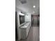 Bathroom featuring dual sinks, gray tile, granite countertops, a large mirror, and a walk-in shower at 23213 Nw Mallard Ave, Dunnellon, FL 34431