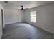 Serene bedroom with neutral walls, grey wood flooring, and a window letting in natural light at 23213 Nw Mallard Ave, Dunnellon, FL 34431