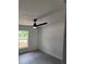 Bedroom featuring a ceiling fan and a window overlooking lush greenery at 23213 Nw Mallard Ave, Dunnellon, FL 34431