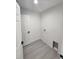 Utility room with grey wood floors, modern washer hookups, and a white door at 23213 Nw Mallard Ave, Dunnellon, FL 34431