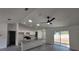 Bright, open-concept living room with sliding doors, a ceiling fan and a kitchen island at 23213 Nw Mallard Ave, Dunnellon, FL 34431