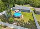 Aerial view of backyard featuring an above ground pool, patio, white fence and mature trees at 2924 Se 142Nd Pl, Summerfield, FL 34491