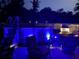 Backyard at night featuring an above ground pool, illuminated with blue lights, providing a relaxing ambiance at 2924 Se 142Nd Pl, Summerfield, FL 34491