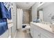 Bathroom boasts a vanity, modern lighting, and a shower with tiled walls at 2924 Se 142Nd Pl, Summerfield, FL 34491