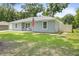 Charming single-story home featuring a well-manicured lawn, American flag, and inviting front porch with rocking chairs at 2924 Se 142Nd Pl, Summerfield, FL 34491