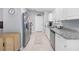 Galley kitchen features white cabinets, stainless steel appliances, and granite countertops at 2924 Se 142Nd Pl, Summerfield, FL 34491