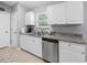 Galley kitchen with granite countertops, stainless steel appliances, and white cabinets at 2924 Se 142Nd Pl, Summerfield, FL 34491