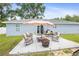 Cozy backyard patio with outdoor seating, umbrella, and a fire pit, ideal for relaxing at 2924 Se 142Nd Pl, Summerfield, FL 34491