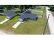 Aerial view of the gray home highlighting its well-manicured lawn, paved driveway, and proximity to neighboring houses at 3094 Se 144Th Pl, Summerfield, FL 34491
