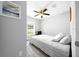 Bright bedroom with a neutral color palette, ceiling fan, and a large window overlooking the back yard at 3094 Se 144Th Pl, Summerfield, FL 34491