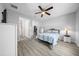 Cozy bedroom with a fan, closet, dresser and ensuite bathroom, with gray wood flooring at 3094 Se 144Th Pl, Summerfield, FL 34491