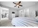 Bedroom with a ceiling fan, light gray wood flooring and ensuite bathroom, walk-in closet, and hall access at 3094 Se 144Th Pl, Summerfield, FL 34491