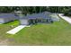 Charming gray home with a well-manicured lawn, paved driveway, and a welcoming exterior, enhancing curb appeal at 3094 Se 144Th Pl, Summerfield, FL 34491