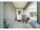 Charming front porch features stylish decor, a welcome mat, and a view of the neighborhood at 3094 Se 144Th Pl, Summerfield, FL 34491