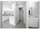 Hallway view leading to a bathroom with a white vanity and shaker cabinets and stainless steel hardware at 3094 Se 144Th Pl, Summerfield, FL 34491
