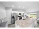 Bright kitchen features stainless steel appliances, white cabinets, and a breakfast bar with lots of counter space at 3094 Se 144Th Pl, Summerfield, FL 34491