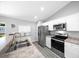 Modern kitchen with stainless steel appliances, white cabinets and bar height counter opening to dining area at 3094 Se 144Th Pl, Summerfield, FL 34491