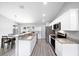 The sleek white kitchen boasts stainless steel appliances, lots of counter space and views of the dining area at 3094 Se 144Th Pl, Summerfield, FL 34491