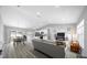 Bright, open-concept living space featuring modern furniture, stylish decor, and hardwood flooring throughout at 3094 Se 144Th Pl, Summerfield, FL 34491