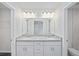 Bright bathroom featuring a double sink vanity with granite countertop, and modern lighting fixtures above the mirror at 3248 Sw 149Th Pl, Ocala, FL 34481