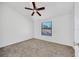 Bedroom with neutral carpet, a ceiling fan, and a large window that provides natural light at 329 Marion Oaks Blvd # A3, Ocala, FL 34473
