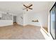 Bright living room featuring neutral tile flooring, a ceiling fan, and a sliding glass door that allows natural light to flood in at 329 Marion Oaks Blvd # A3, Ocala, FL 34473