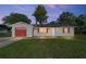 Charming single-story home with red garage door, shutters, and green lawn at 3428 Ne 17Th Ter, Ocala, FL 34479