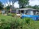 Landscaped backyard with a pool, deck, screened porch, and mature trees at 3709 Ne 4Th St, Ocala, FL 34470