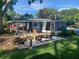 Backyard with a patio, fire pit, and shaded seating adjacent to lush landscaping at 3709 Ne 4Th St, Ocala, FL 34470