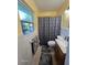 Small bathroom with patterned shower curtain, tiled walls, and window at 3709 Ne 4Th St, Ocala, FL 34470