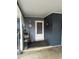 Cozy covered porch with a white front door, a small shelving unit, and neutral-toned walls for a welcoming entrance at 3709 Ne 4Th St, Ocala, FL 34470