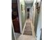 Long hallway with framed art leading to various rooms, with a decorative rug adding character to the space at 3709 Ne 4Th St, Ocala, FL 34470