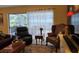 Bright living room featuring a black recliner, patterned armchair, and an ornate side table, all atop an area rug at 3709 Ne 4Th St, Ocala, FL 34470