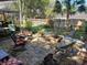 Outdoor brick patio area with fire pit, shaded by trees, and furnished with wicker chairs at 3709 Ne 4Th St, Ocala, FL 34470