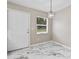 Bright entryway featuring marble tile floor and modern light fixture near a window at 4250 Nw 26Th Ter, Ocala, FL 34475