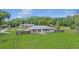 Exterior view of the backyard shows the home with wood fencing, mature trees and green lawn at 4250 Nw 26Th Ter, Ocala, FL 34475