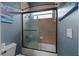 Tiled bathroom features a tub and shower with a sliding glass door and a window for natural light at 4731 Se 34Th St, Ocala, FL 34480
