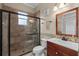 Tiled bathroom with glass-enclosed shower, a single sink vanity, and earth-tone accents at 4731 Se 34Th St, Ocala, FL 34480