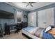This primary bedroom features blue walls, a ceiling fan, and a large window, creating a cozy atmosphere at 4731 Se 34Th St, Ocala, FL 34480