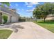Long driveway leading to a three-car garage, set against a backdrop of green lawn and mature trees at 4731 Se 34Th St, Ocala, FL 34480