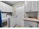 Well-equipped laundry room with white cabinets, utility sink, washer, and dryer for convenience at 4731 Se 34Th St, Ocala, FL 34480