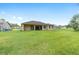 Large backyard with green grass and a covered patio area, great for outdoor activities and gatherings at 5024 Sw 114Th Street Rd, Ocala, FL 34476