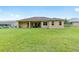 Spacious backyard featuring a well-maintained lawn and a covered patio, perfect for outdoor entertaining at 5024 Sw 114Th Street Rd, Ocala, FL 34476