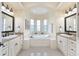 Bright bathroom featuring double sinks, granite countertops, a soaking tub and tiled floors at 5024 Sw 114Th Street Rd, Ocala, FL 34476