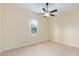 Bright, carpeted bedroom with a ceiling fan and a window for natural lighting at 5024 Sw 114Th Street Rd, Ocala, FL 34476
