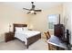 Cozy bedroom with wooden furniture, fan and light fixture, and a window for natural light at 5024 Sw 114Th Street Rd, Ocala, FL 34476