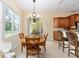 Bright dining area featuring a wood table set, chandelier, and sliding glass doors to the outside at 5024 Sw 114Th Street Rd, Ocala, FL 34476