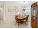 Traditional dining area showcasing a wooden table, chandelier, and ample natural light at 5024 Sw 114Th Street Rd, Ocala, FL 34476