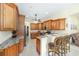 Kitchen with raised breakfast bar, granite counters, and wood cabinetry at 5024 Sw 114Th Street Rd, Ocala, FL 34476